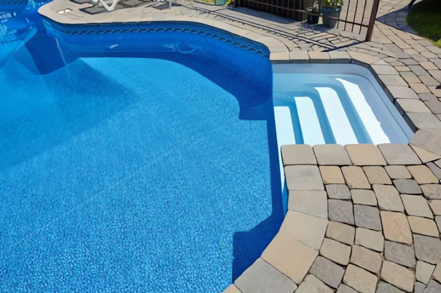 A Blue Swimming Pool with Stairs Leading to It — Concrete Colour Solutions in Nelson Bay, NSW