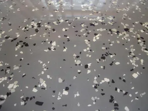 A close up of a gray floor with black and white chips on it — Concrete Colour Solutions in Morisset, NSW