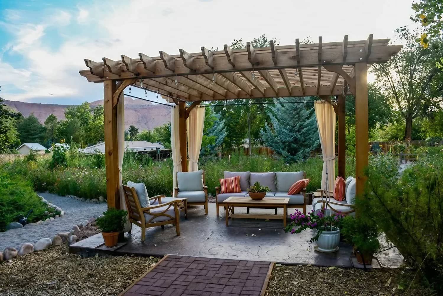 A Wooden Pergola with A Couch and Chairs Underneath It — Concrete Colour Solutions in Heatherbrae, NSW