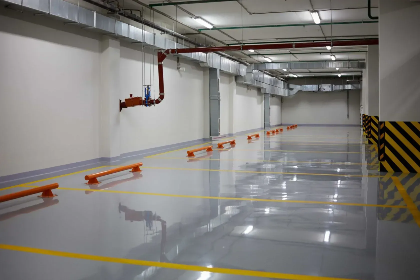 An Empty Parking Garage with A Concrete Floor and Yellow Lines — Concrete Colour Solutions in Heatherbrae, NSW