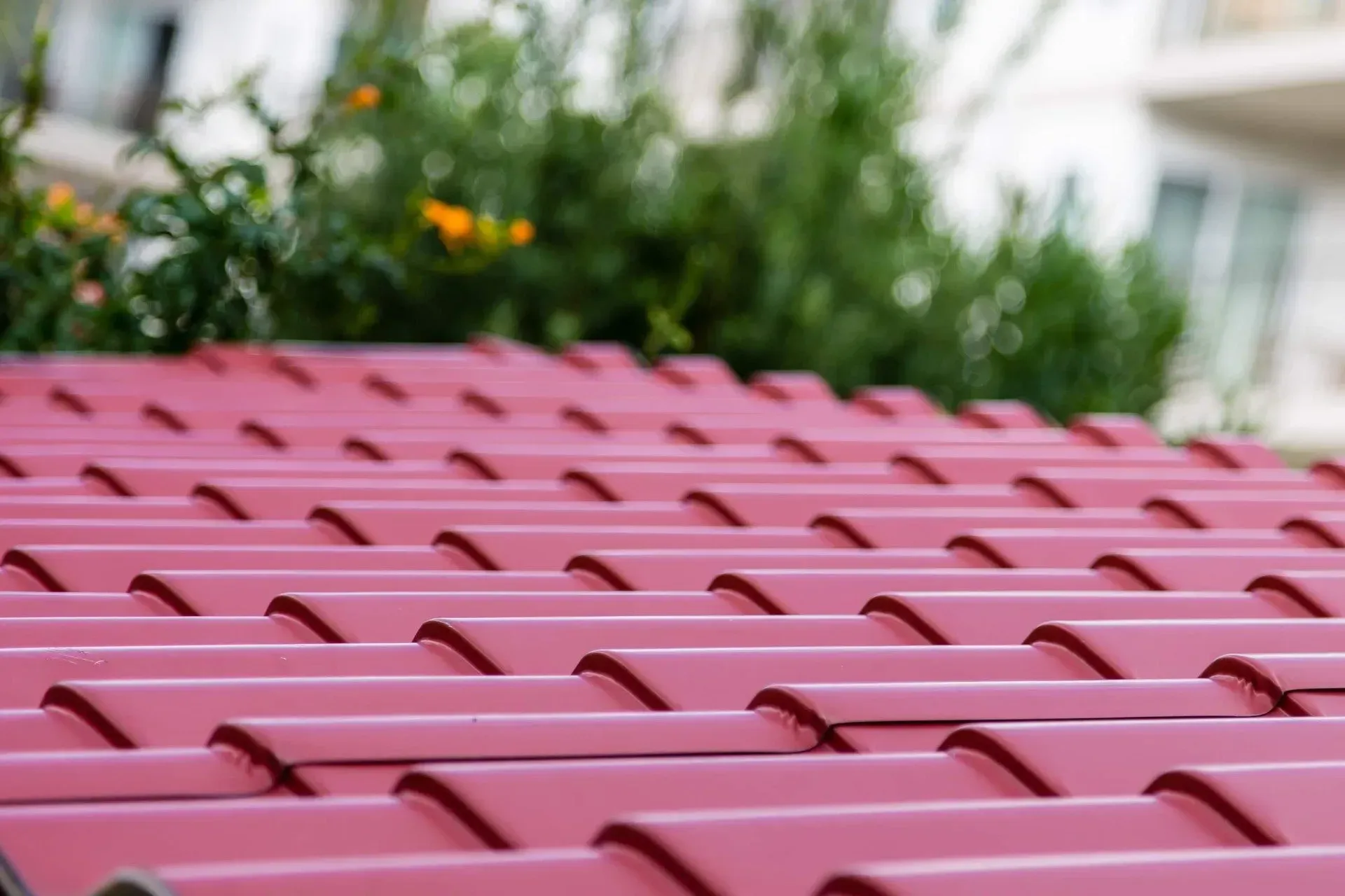 A Close up Of a Red Roof with Flowers in The Background — Concrete Colour Solutions in Heatherbrae, NSW