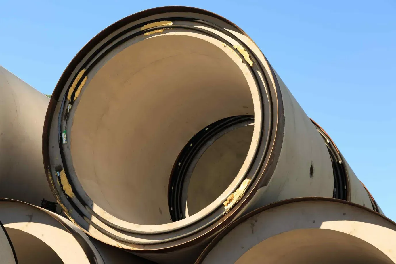 A Bunch of Pipes Are Stacked on Top of Each Other — Concrete Colour Solutions in Lake Macquarie, NSW