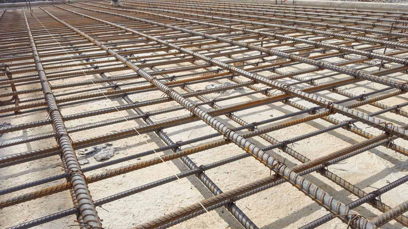 A Close up Of a Concrete Floor with A Grid of Steel Bars — Concrete Colour Solutions in Nelson Bay, NSW