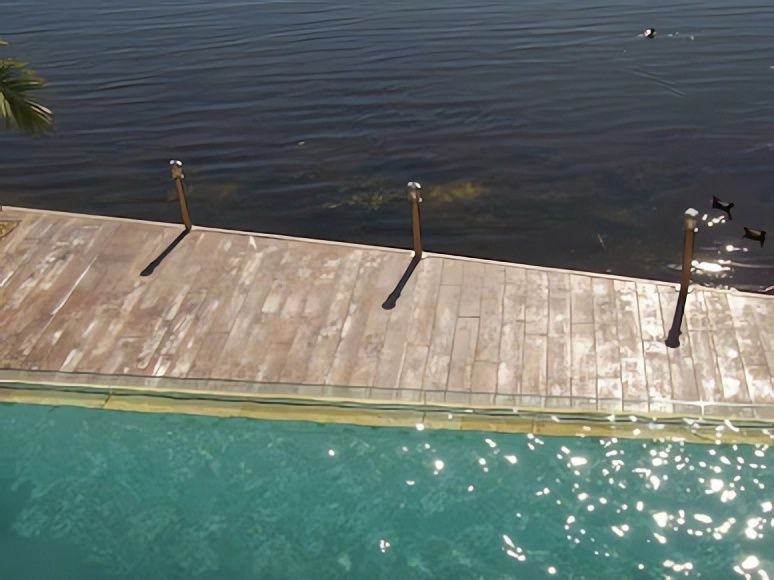 A Wooden Deck Overlooking a Large Body of Water — Concrete Colour Solutions in Maitland, NSW