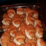 Tray of freshly baked croissants, golden-brown and piled together