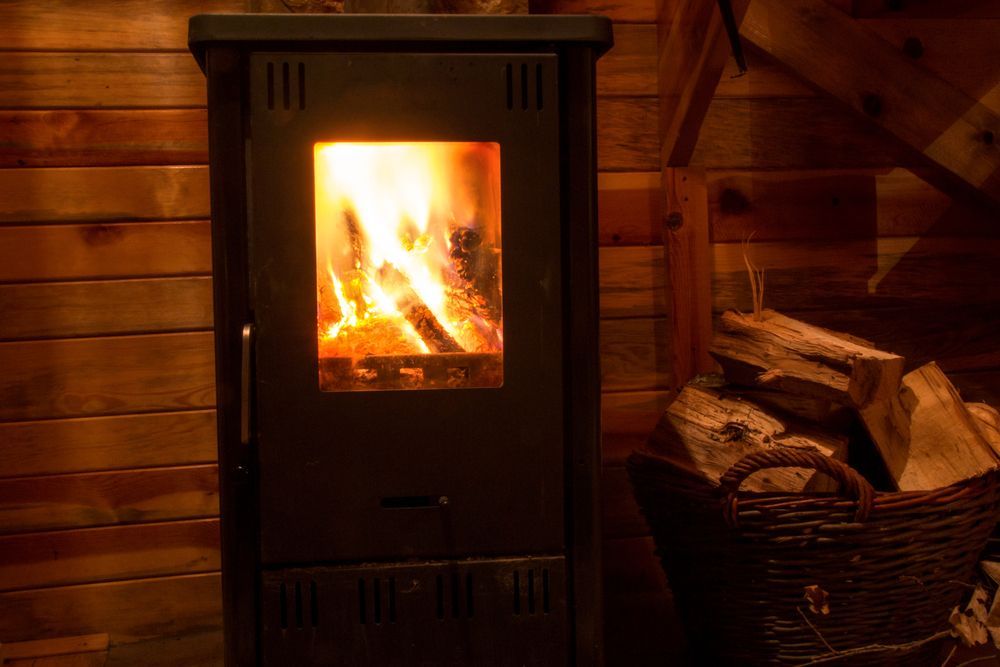 A Black Wood-burning Stove With a Glowing Fire Inside — The Flue Pro In Huntingfield, TAS