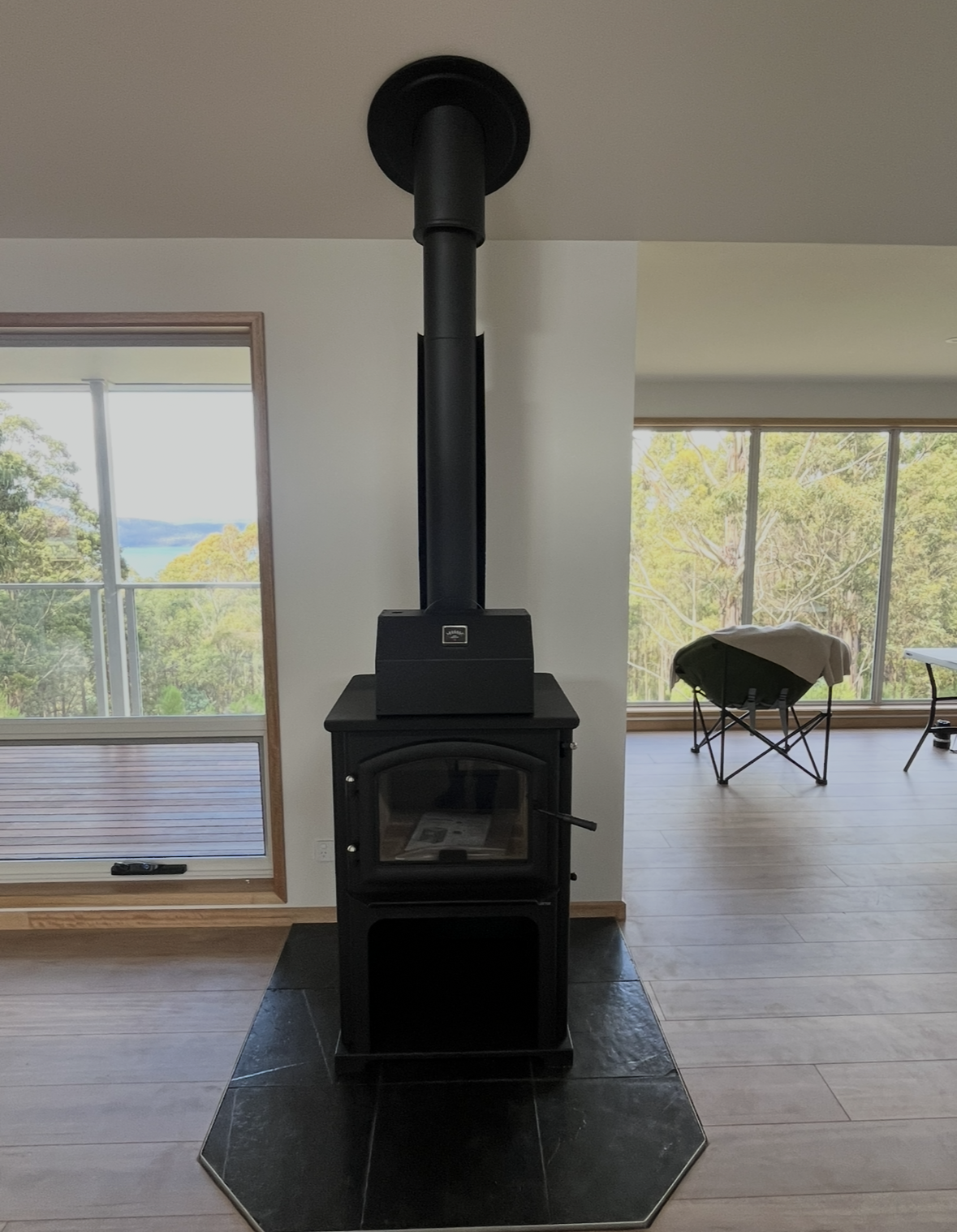 Black Wood Stove With Tall Flue in a Bright Room — The Flue Pro In Devonport, TAS