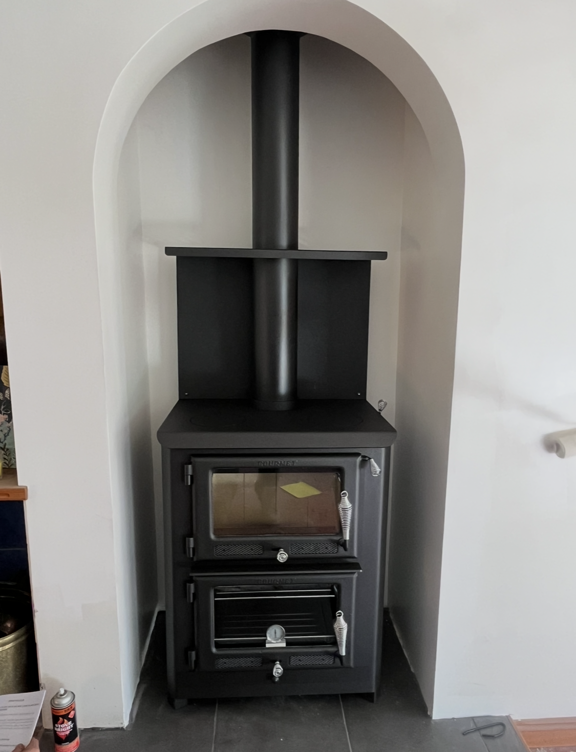 Black Wood-burning Stove in a White Arched Fireplace Nook — The Flue Pro In Burnie, TAS