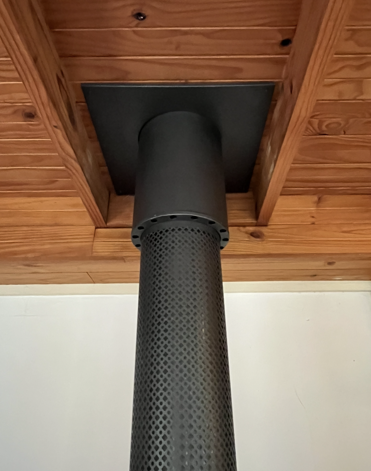Cylindrical Chimney Pipe Extending Through a Wooden Ceiling Panel — The Flue Pro In Devonport, TAS