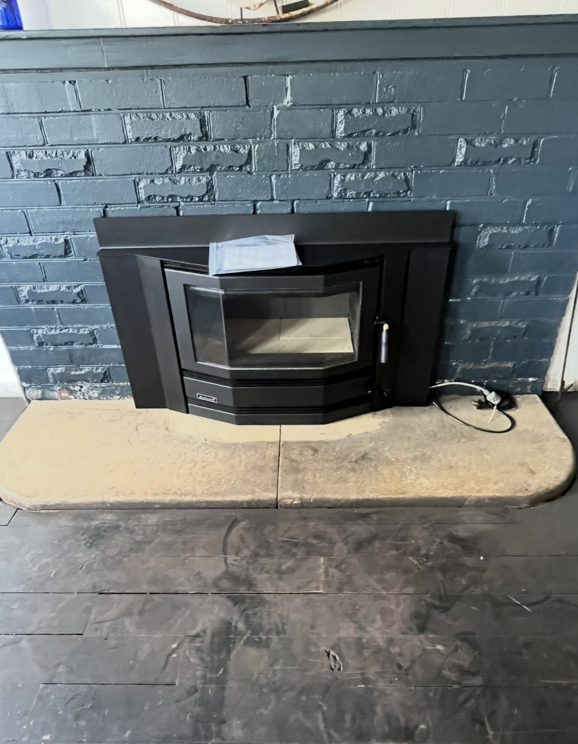 Black Fireplace Insert Set Into a Blue-grey Brick Wall — The Flue Pro In Burnie, TAS