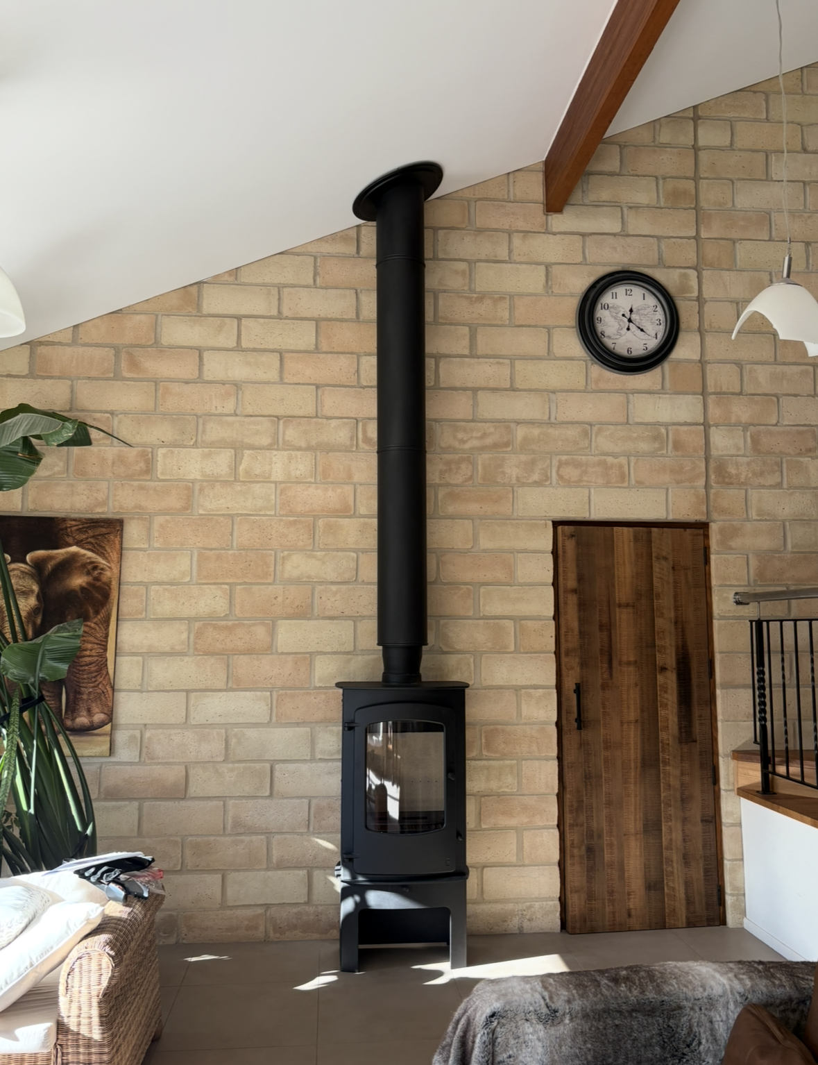 Stone Wall With Black Wood Stove and Chimney — The Flue Pro In Burnie, TAS