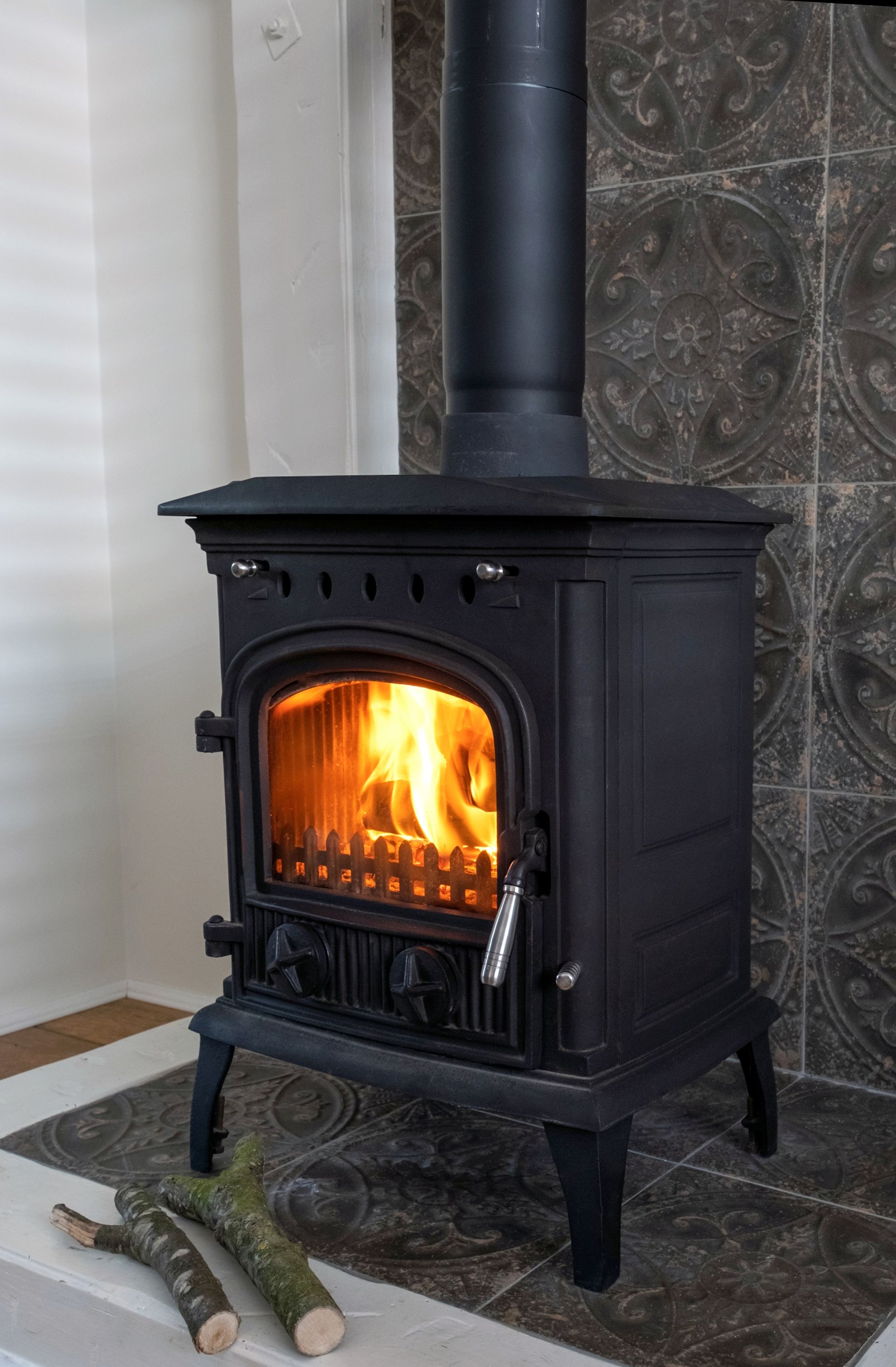 A Black Cast-iron Wood Stove With a Burning Fire — The Flue Pro In Huntingfield, TAS