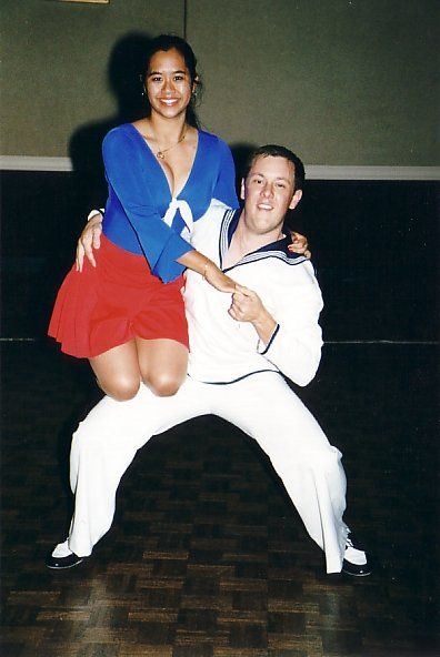 A man is holding a woman in his arms on a dance floor