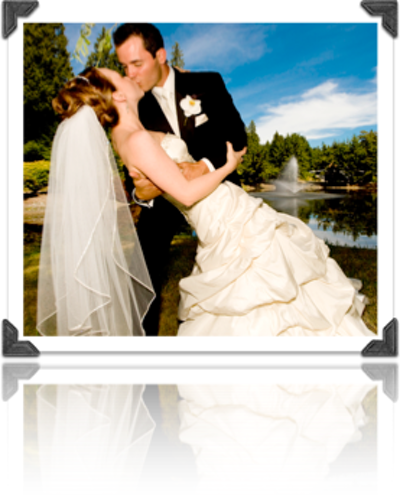 A bride and groom kissing in front of a fountain