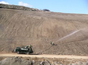 CDTS's largest hydroseeder, a 6,000-litre Finn lorry-mounted unit, applying hydraulic seeding mulch to a steep embankment.