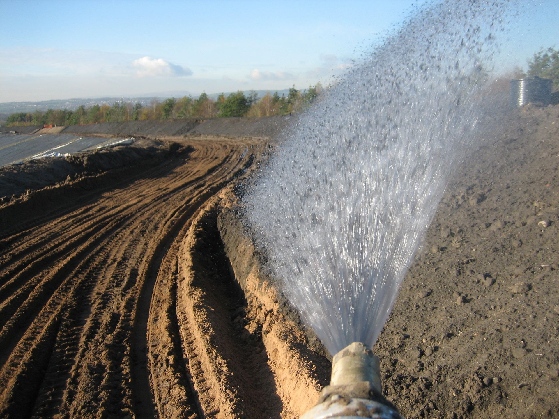 Hydroseeding a disused quarry. Application with fan nozzle for even coverage of BFM.