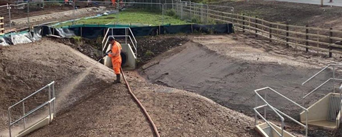 A CDTS operative applying hydraulic seeding mulch to a drainage system to prevent run-off. 