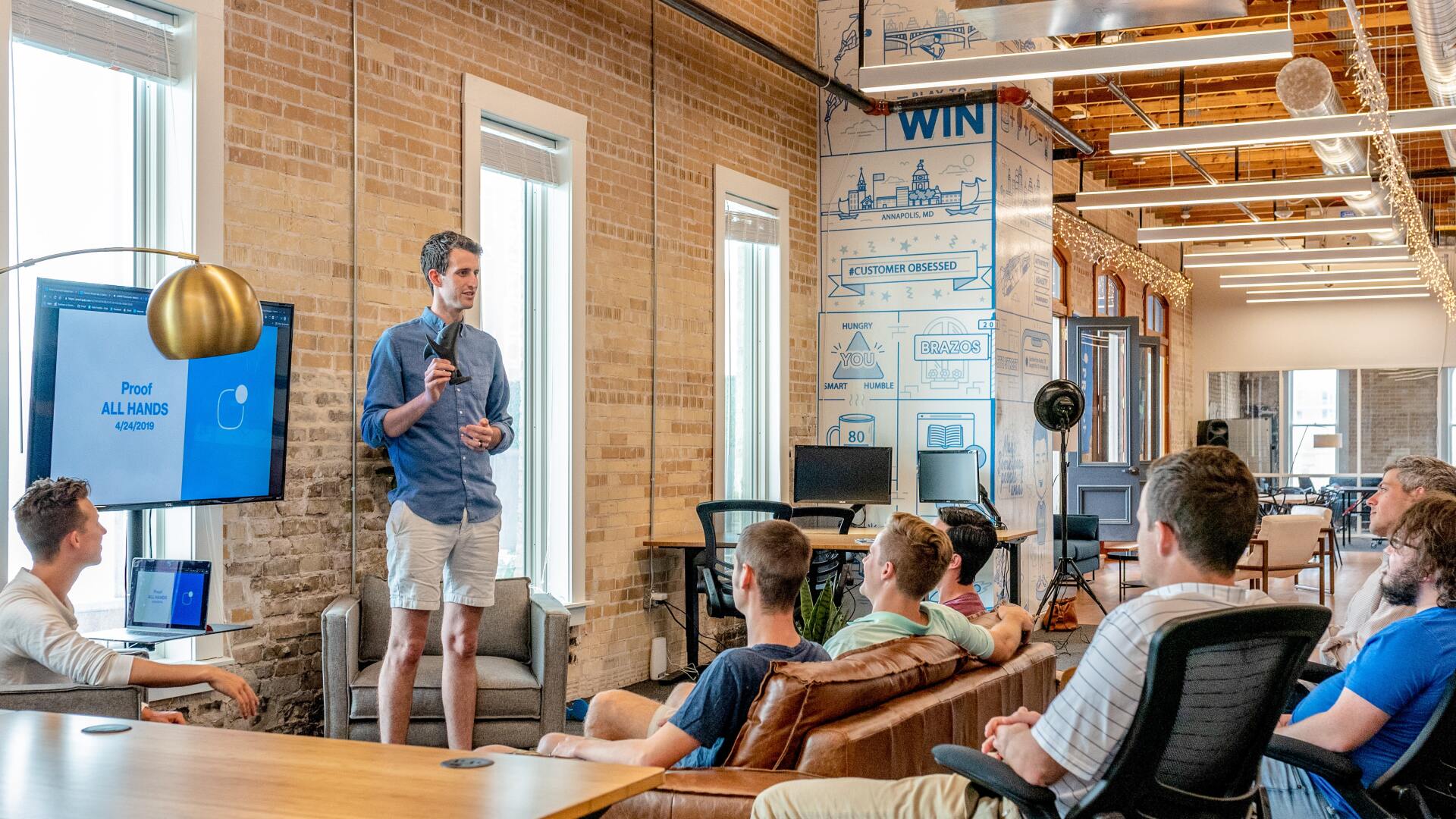Man presenting to a small group of people sitting.