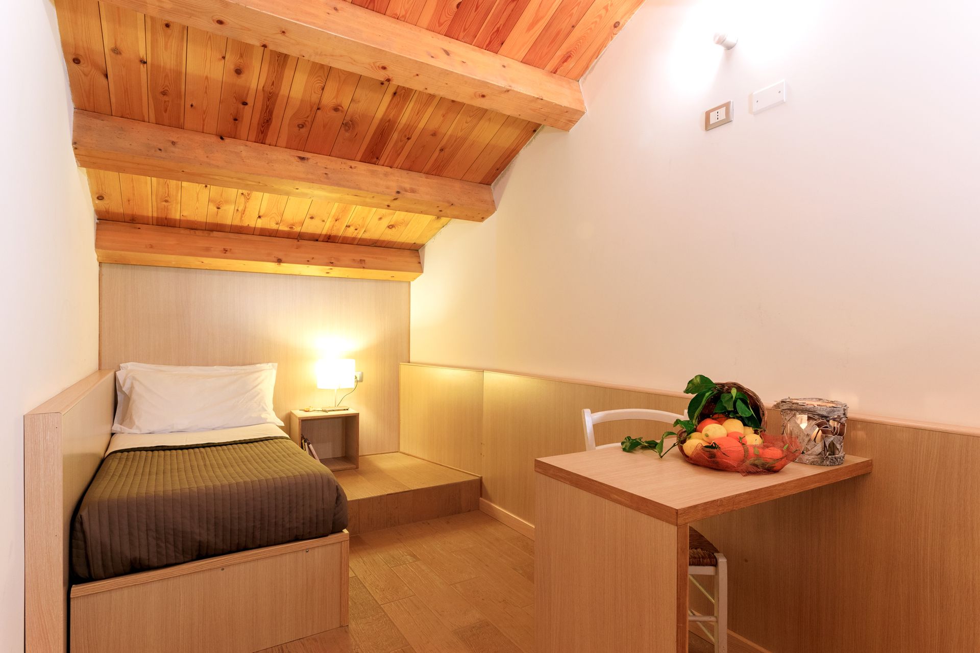 Piccola e accogliente camera da letto con letto singolo, travi in legno.