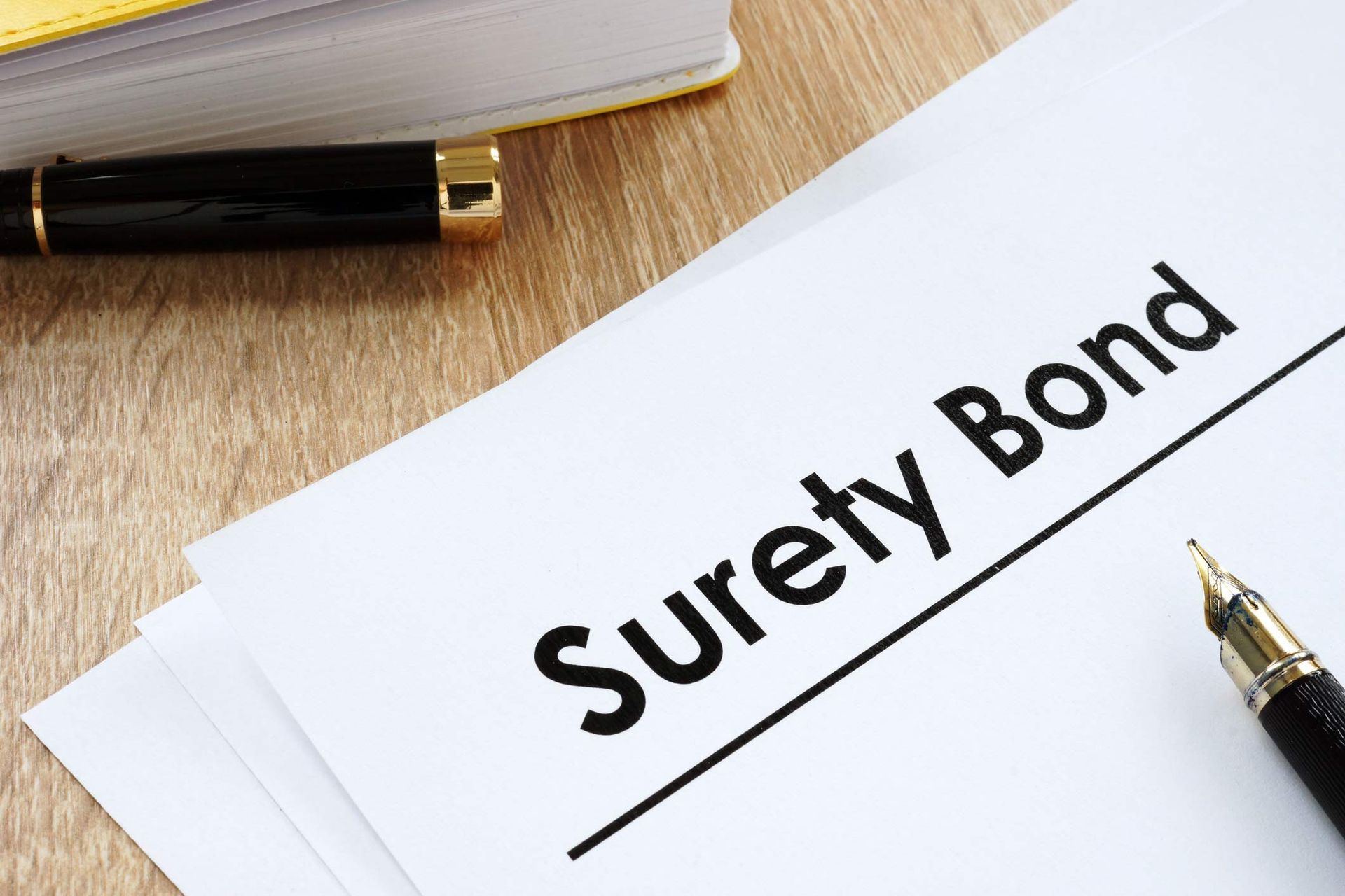 Surety Bond Form And Pen On A Table — Vero Beach, FL — Barnett Bail Bonds Writing bail bonds for those in Palm Bay, FL