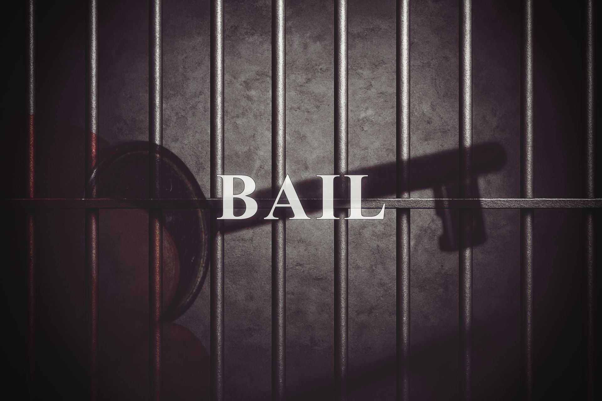 Close-up of metal jail bars with a key, representing bail and 24-hour bail bond service.