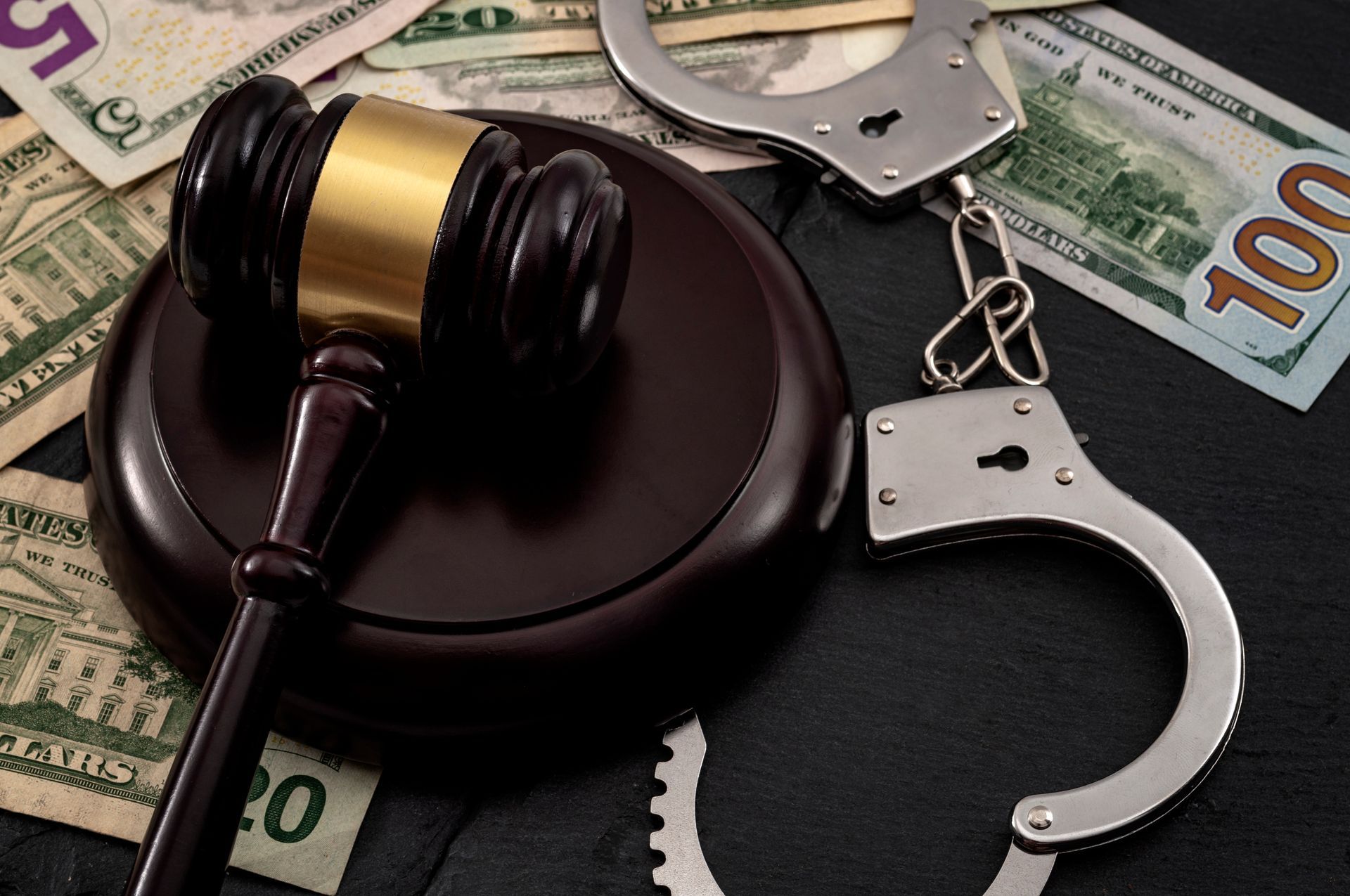 Gavel, handcuffs, and U.S. dollar bills symbolizing crime and legal justice