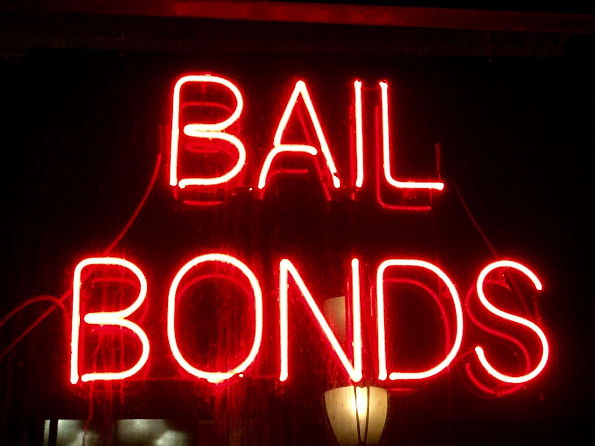 A red neon sign with text | ] 24/7 Bail Bonds Service in Indian River County FL | Barnett Bail Bonds