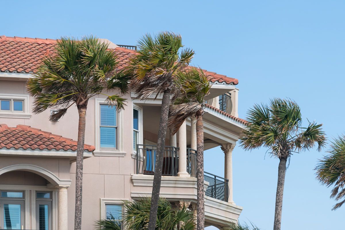 A large house with palm trees in front of it.