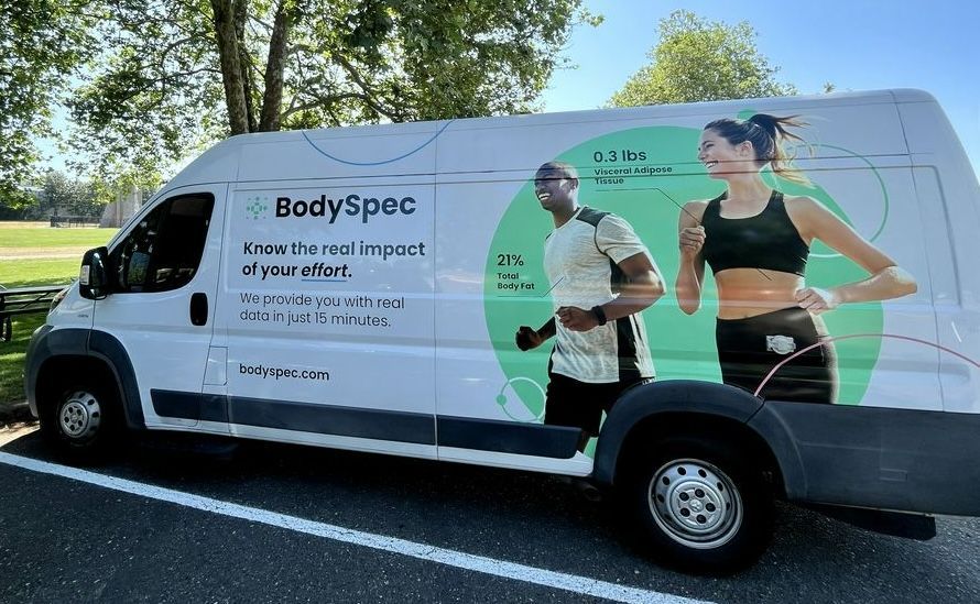 A body spec van is parked in a parking lot.