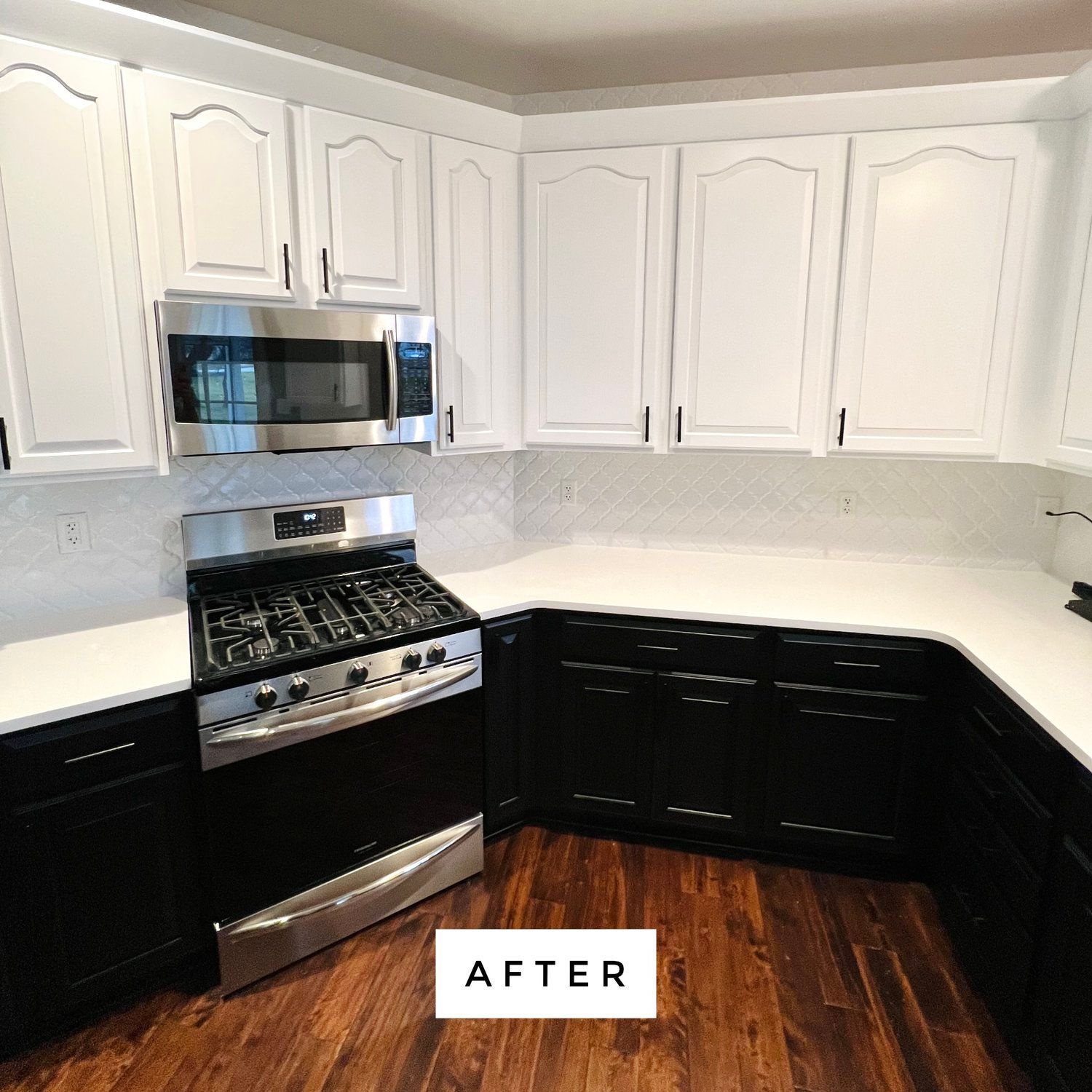 Kitchen with white upper cabinets, black lower cabinets, and stainless steel appliances.