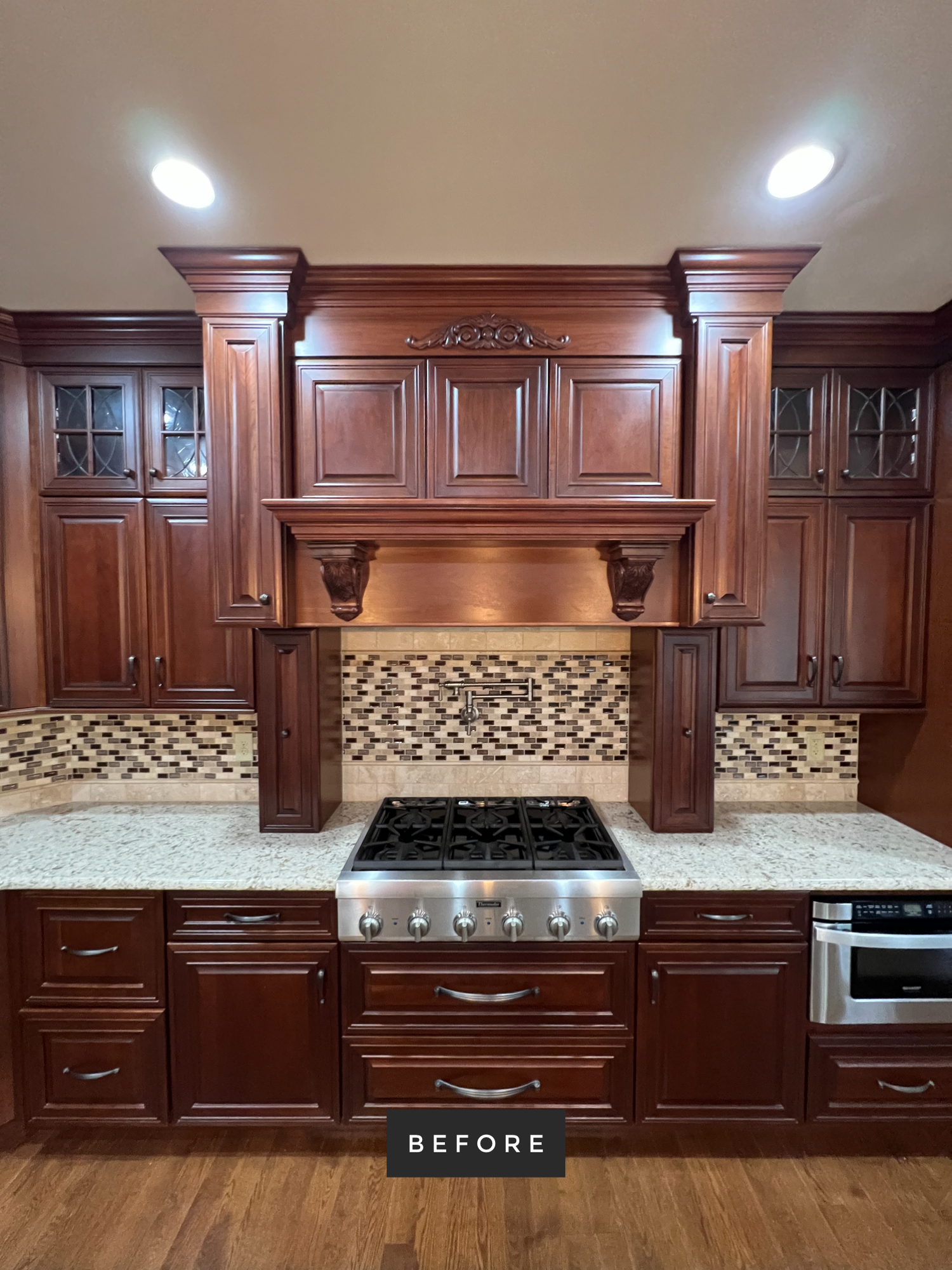 Cherry wood kitchen with stainless steel range, granite countertops, and decorative backsplash.