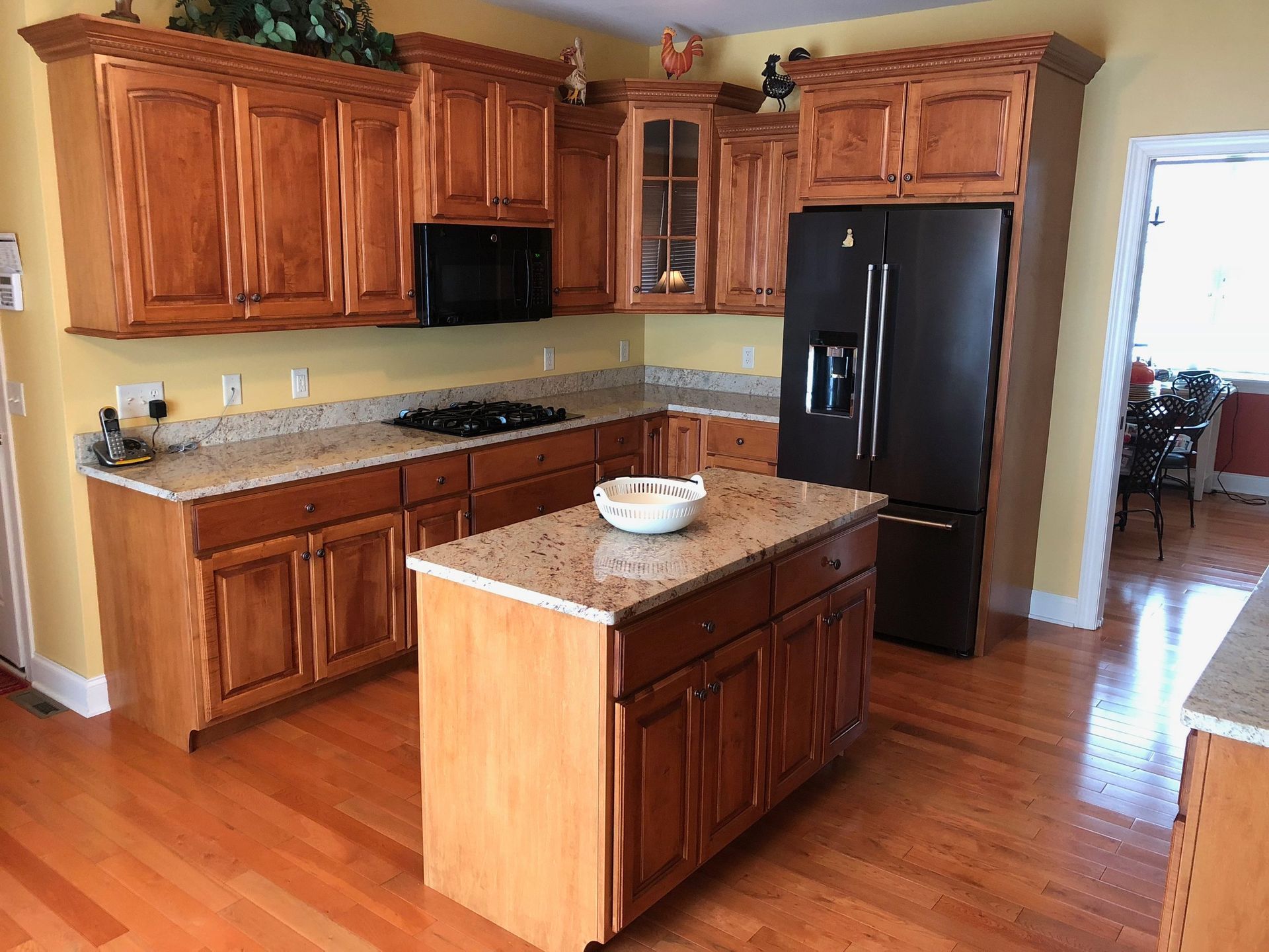 Kitchen with wood cabinets, granite countertops, and a black refrigerator.