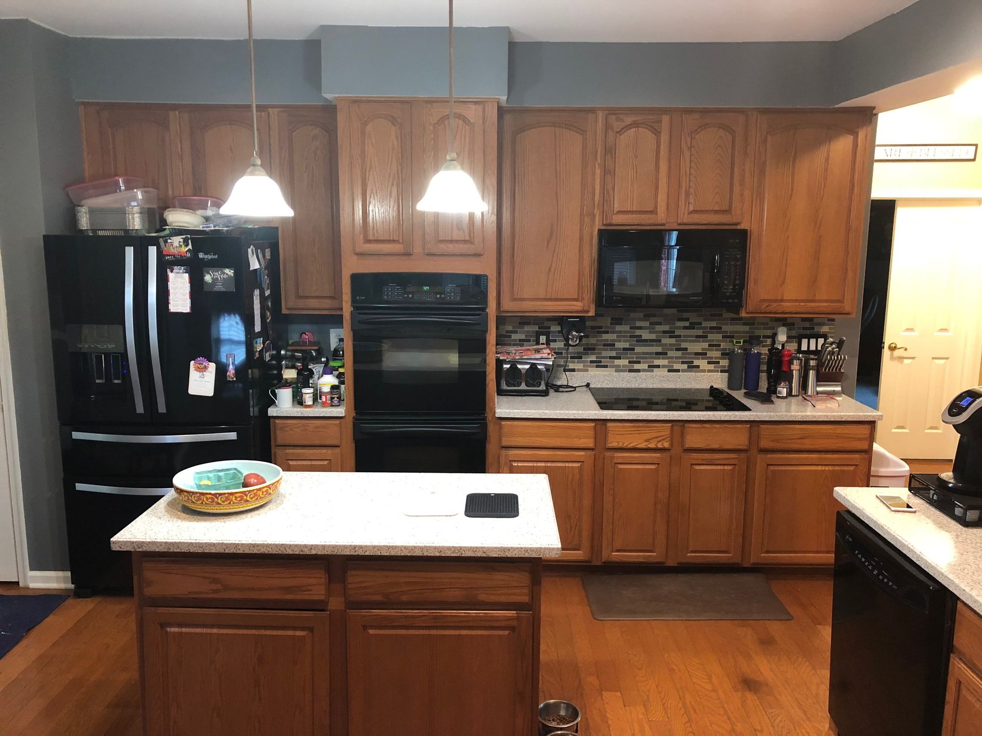 Kitchen with wooden cabinets, black appliances, and a center island with a white countertop.