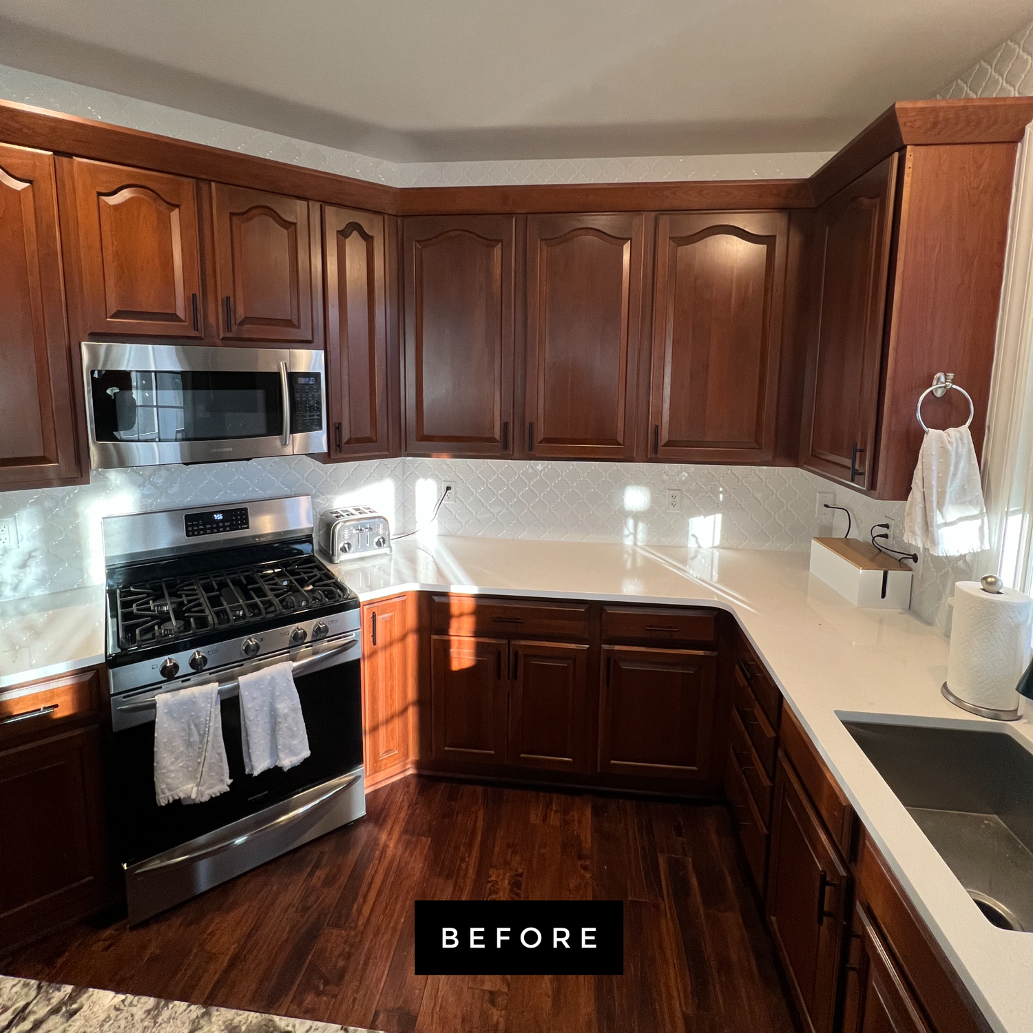 Kitchen with dark wood cabinets, white countertops, stainless steel appliances, and a 