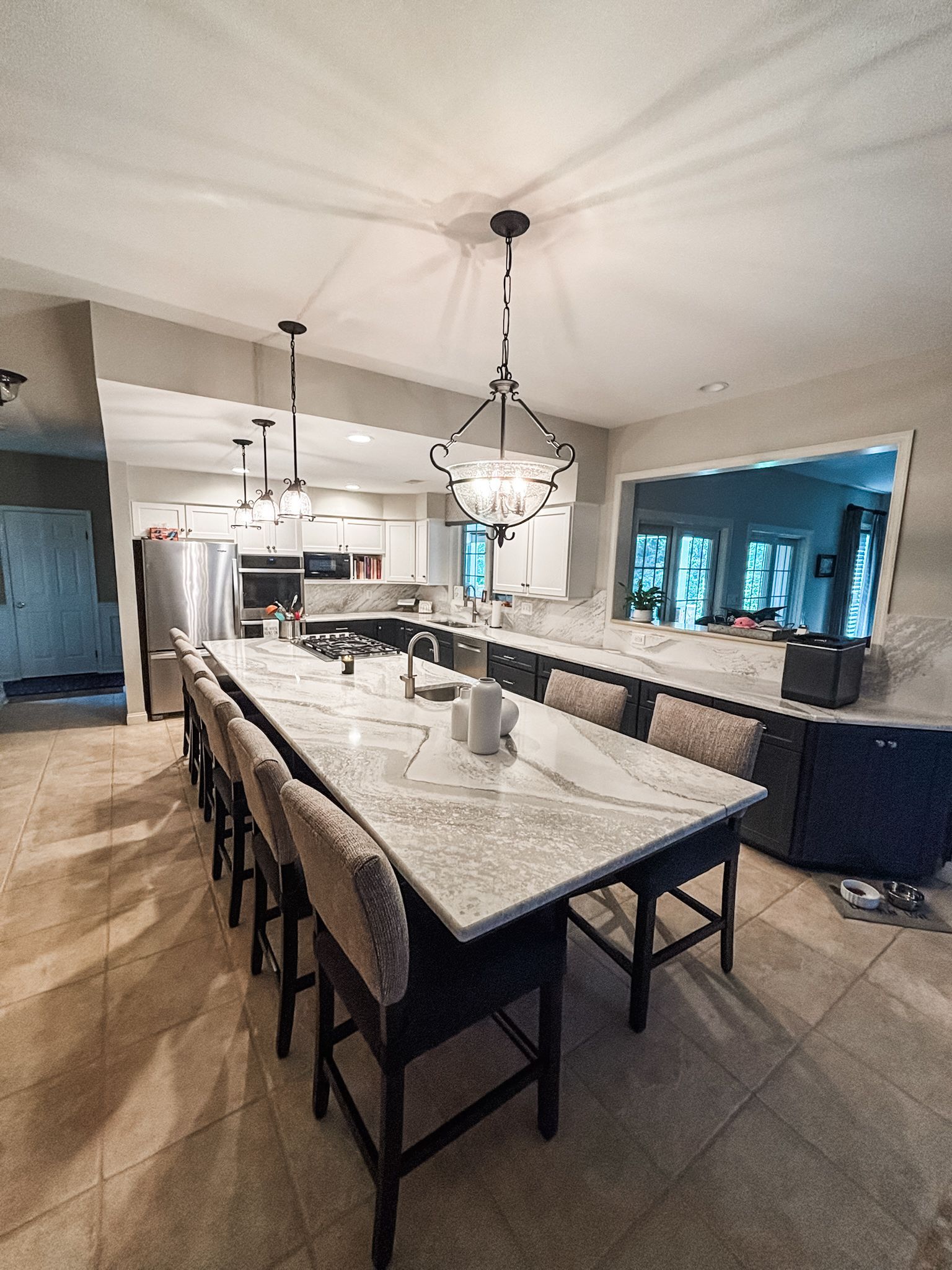 Kitchen with white cabinets, dark speckled granite countertop, black faucet, and a patterned window valance.