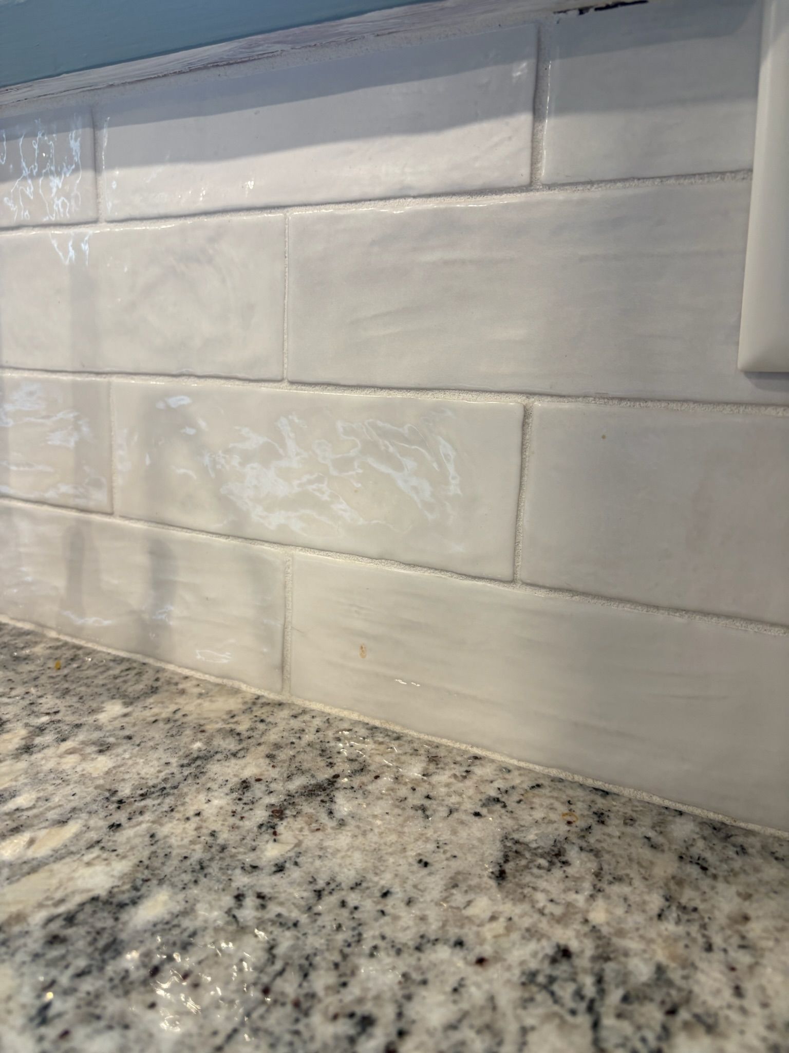 White subway tile backsplash with a granite countertop.
