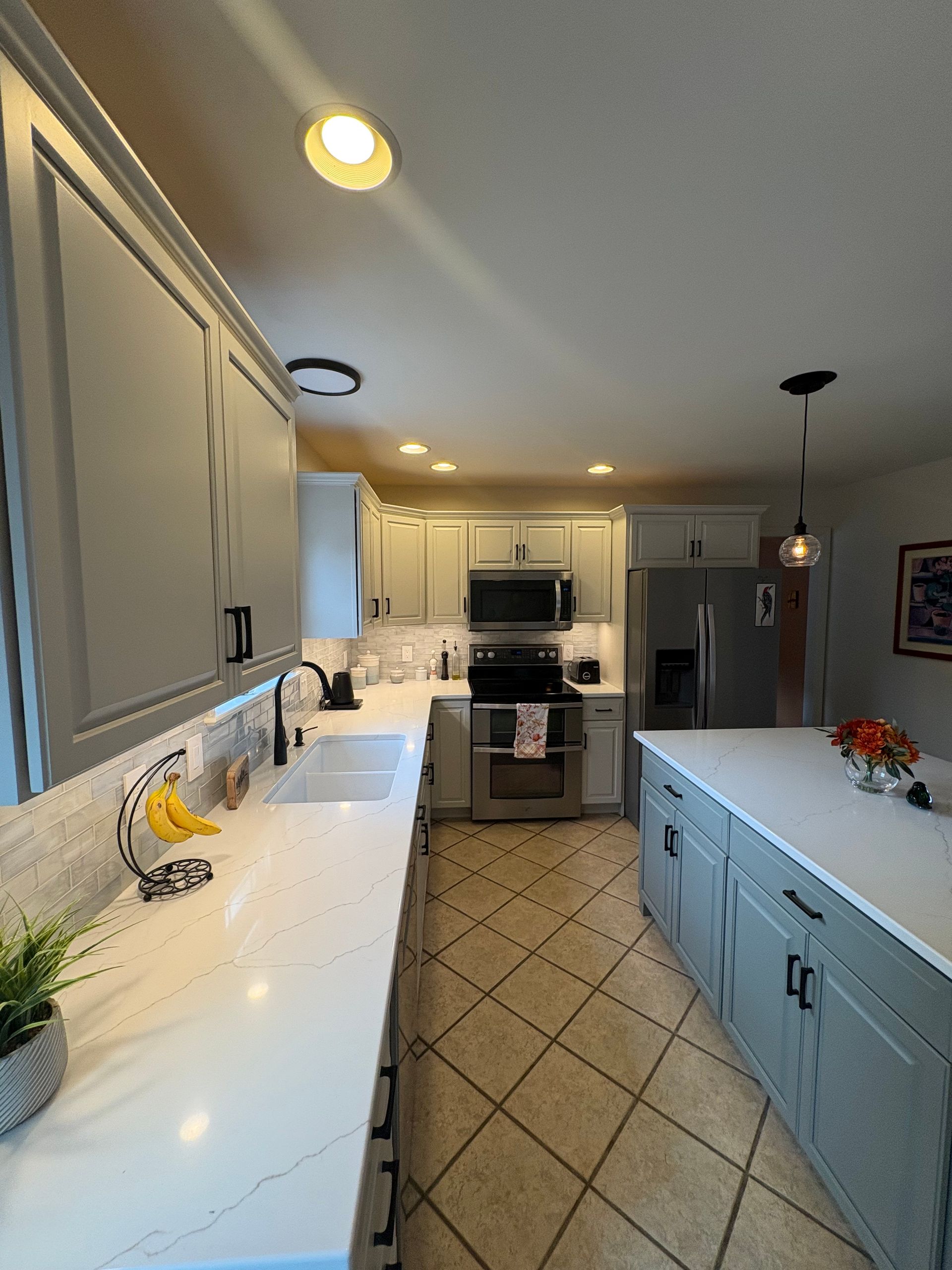 Gray and white kitchen with a kitchen island and modern appliances.