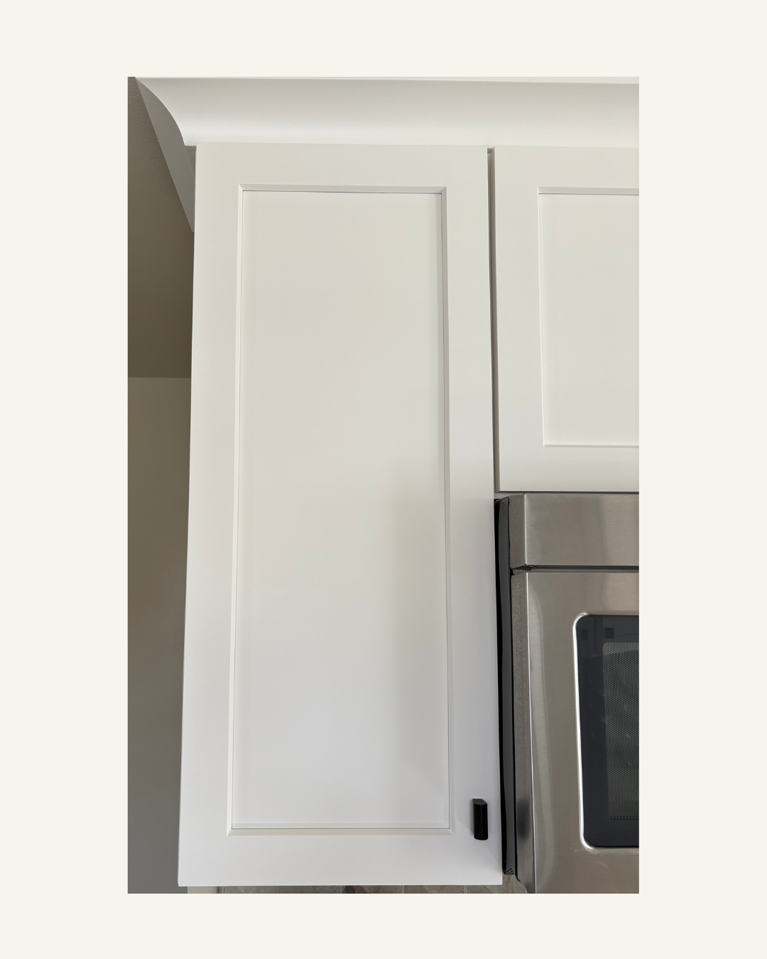 White kitchen cabinet with a microwave below.