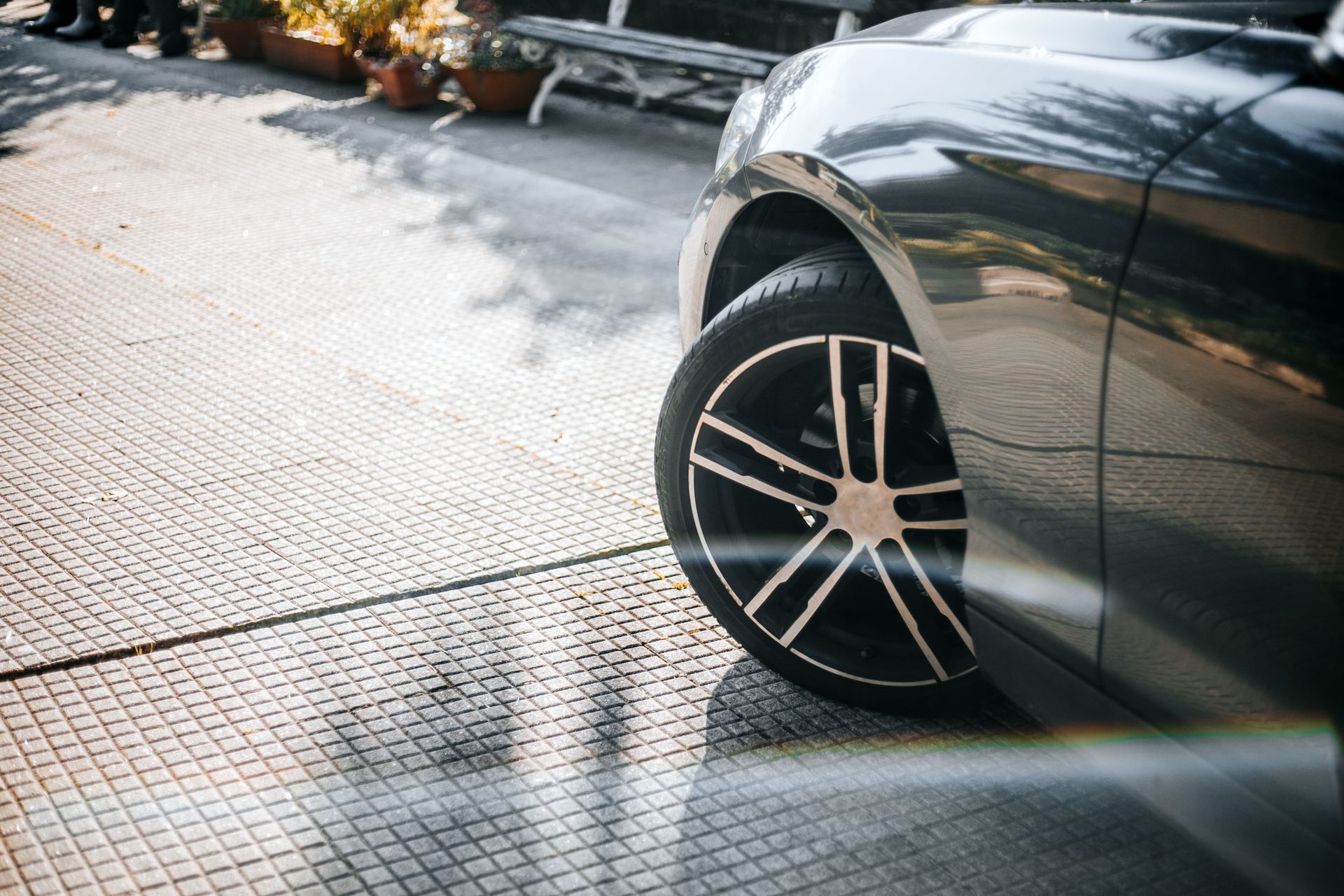 A black car is parked on the side of the road.