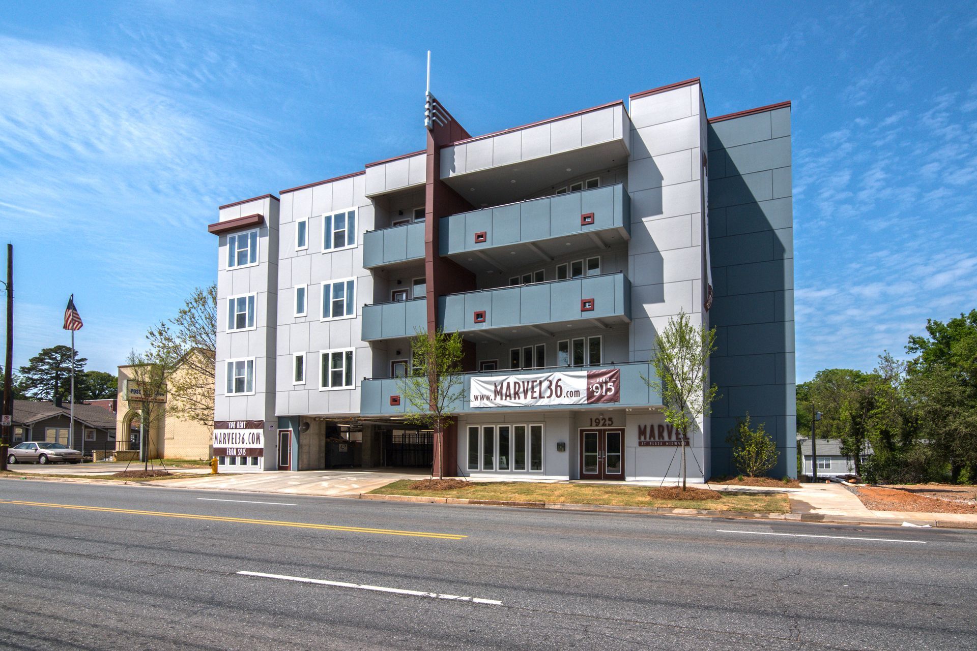 Modern gray apartment building with balconies on a sunny day at Marvel Apartments.