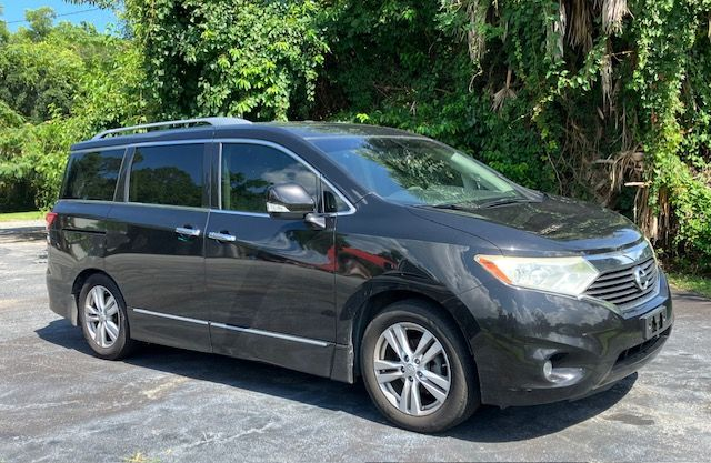Black Nissan Quest minivan parked outdoors on a sunny day.