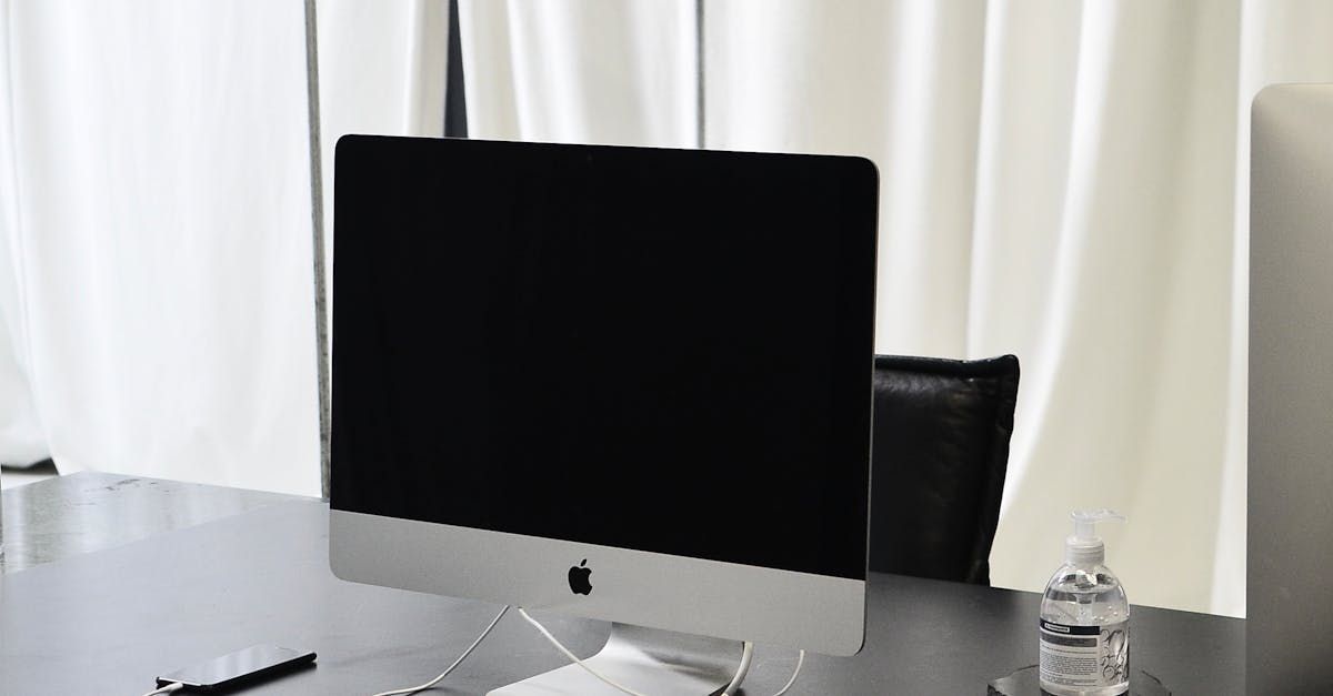 A computer monitor is sitting on a desk in front of a window.