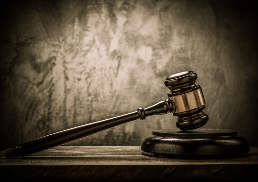 A judge 's gavel is sitting on top of a wooden table.