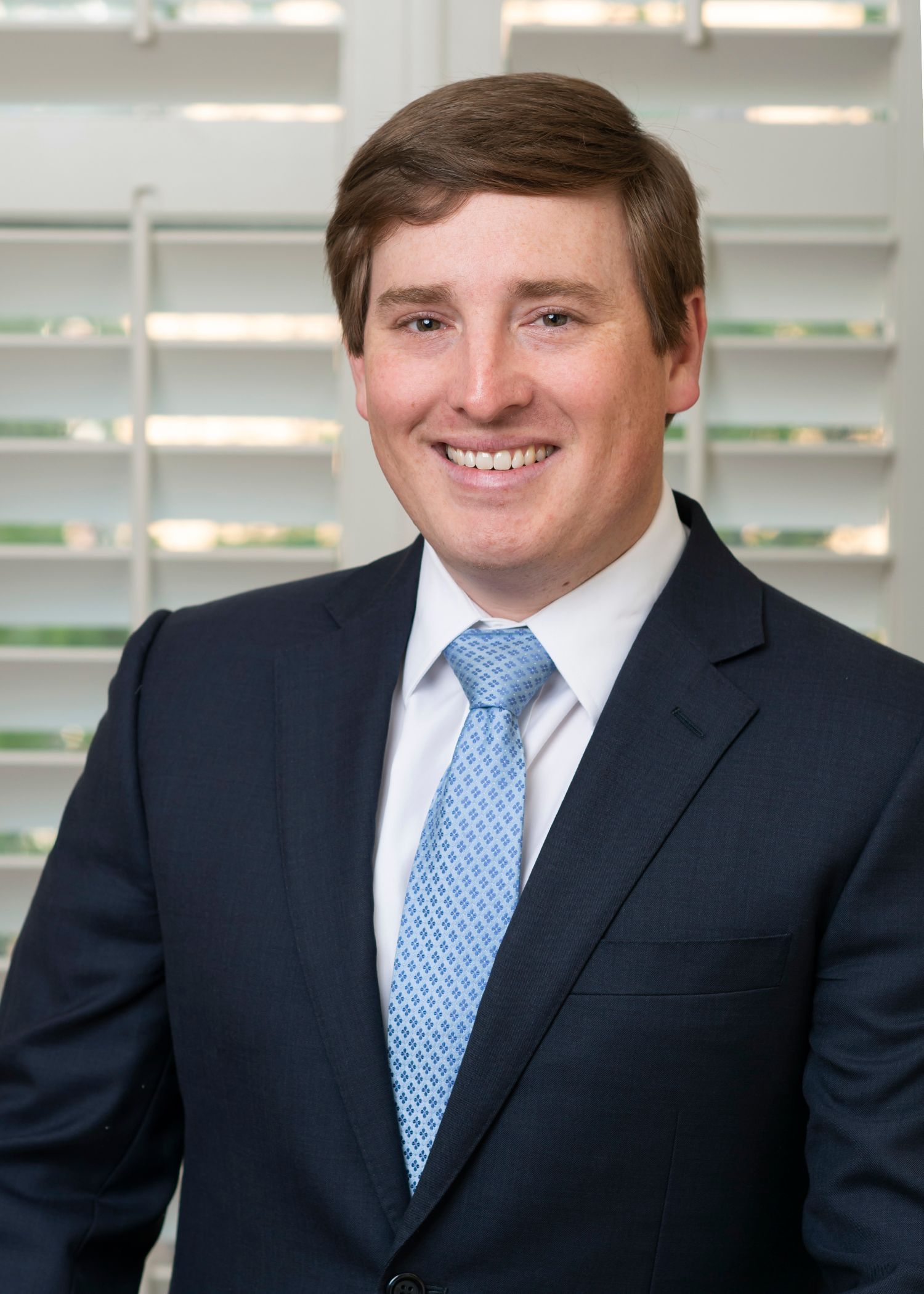 A man in a suit and tie is smiling for the camera.