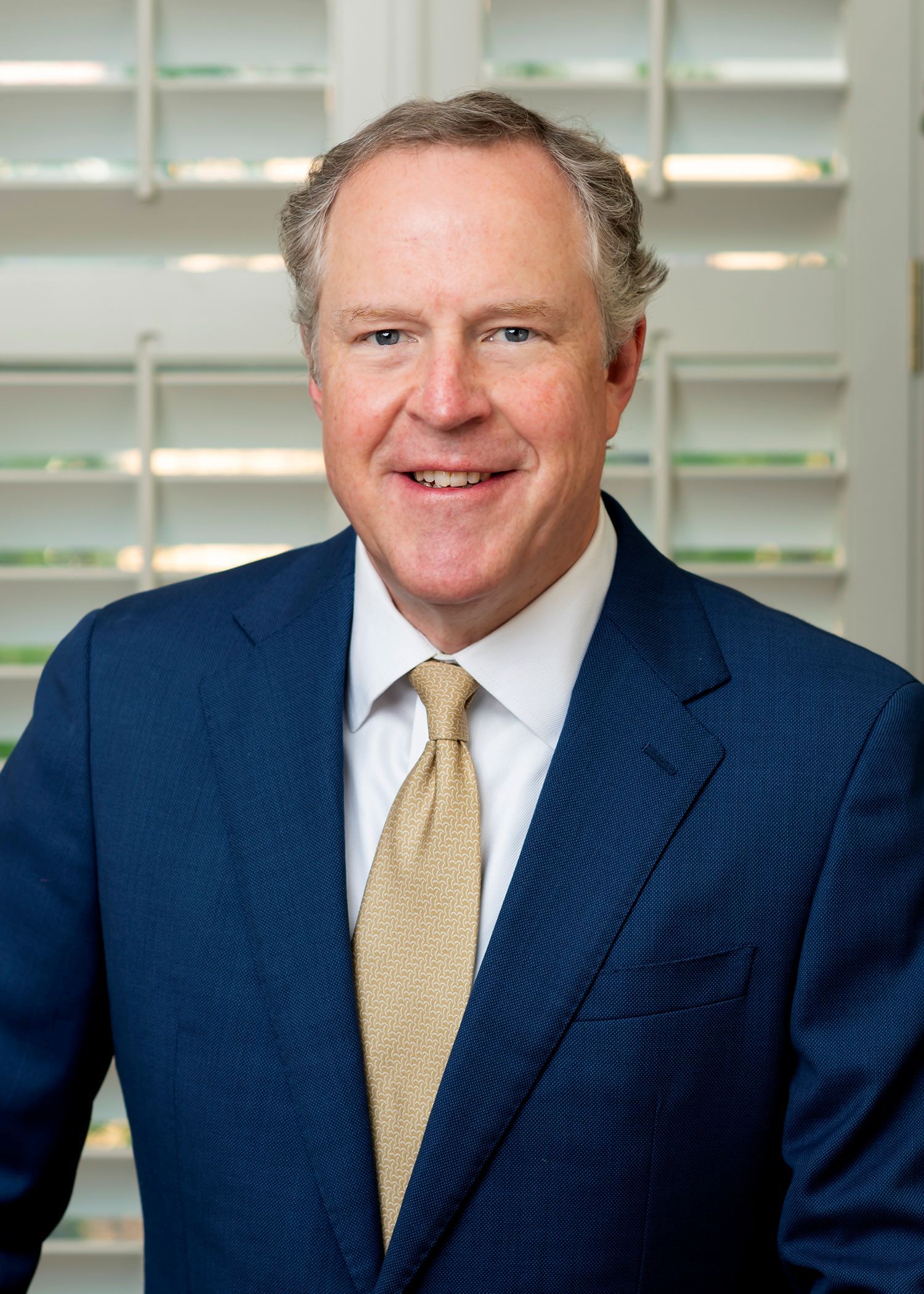 A man in a suit and tie is smiling for the camera.