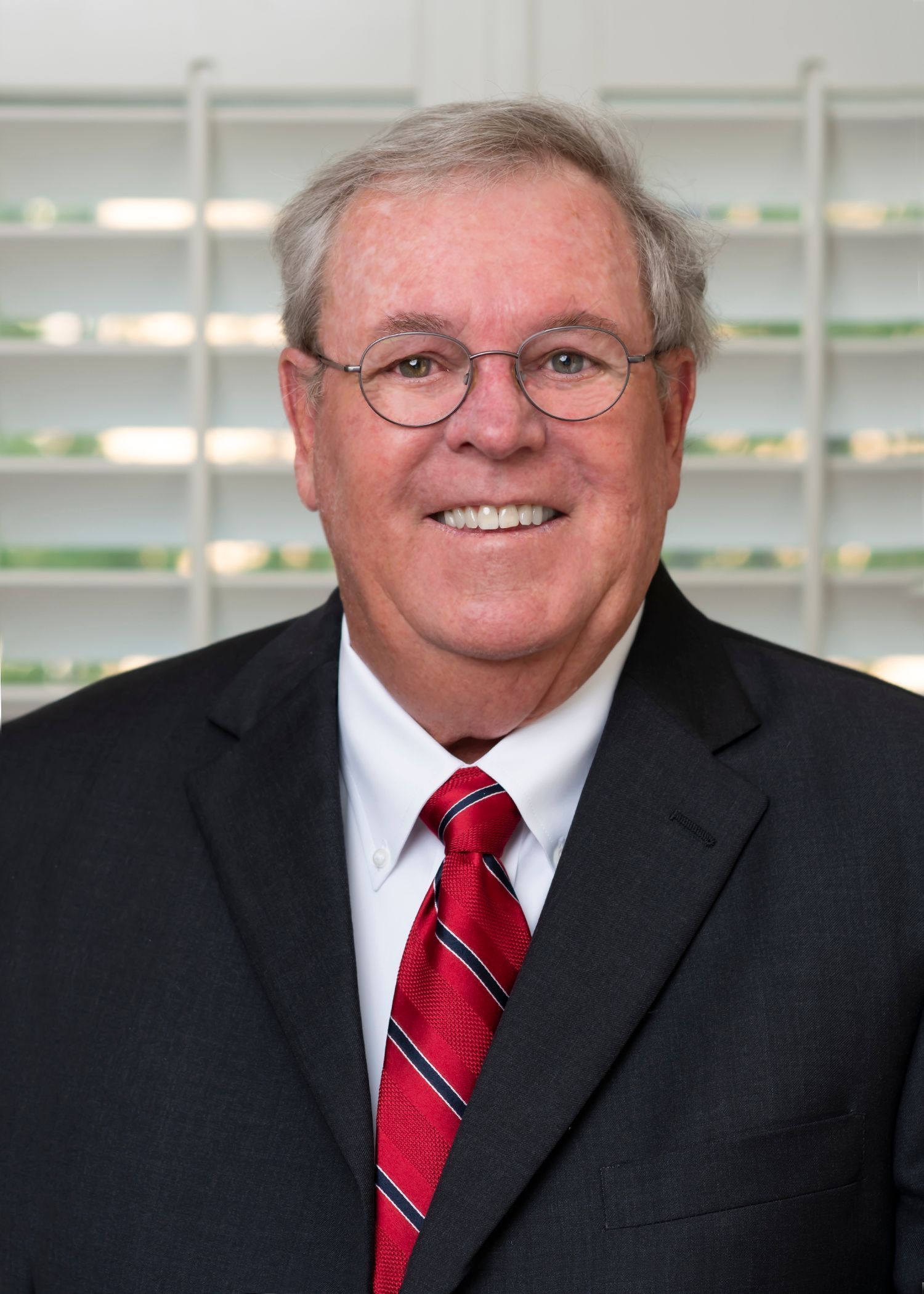 A man in a suit and tie is smiling for the camera