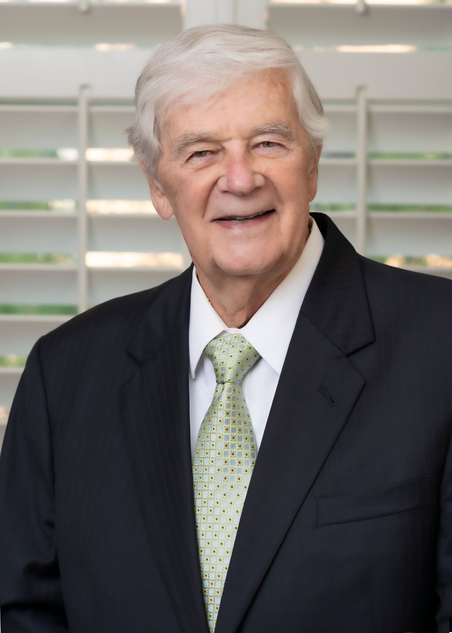 A man in a suit and tie is smiling for the camera