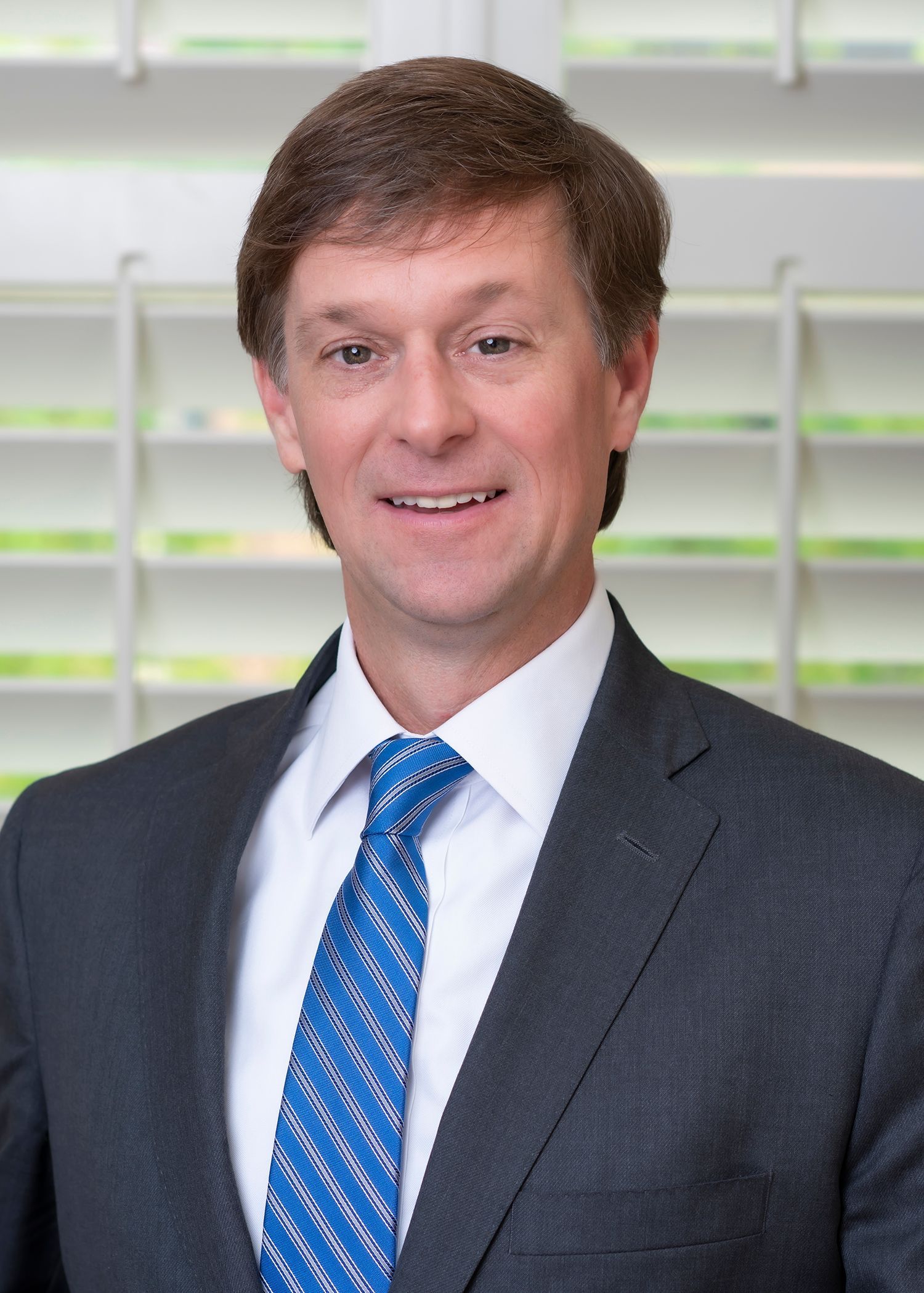 A man in a suit and tie is smiling for the camera.