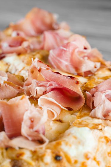 Pizza con prosciutto, primo piano.