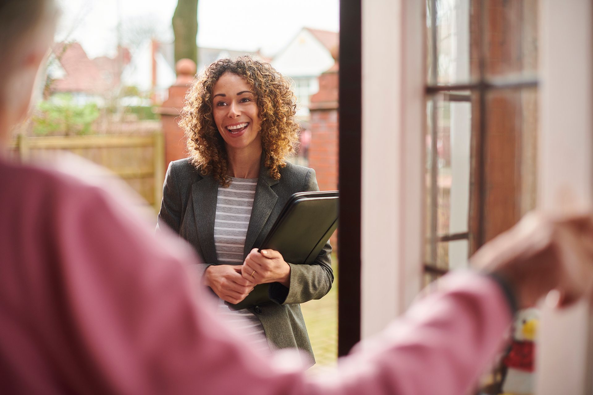 A woman is standing in a doorway talking to a man.